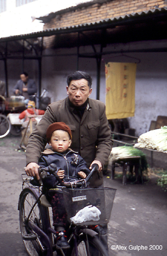 Photographie Couleur - Verticale - Vieil homme promenant un jeune enfant sur son vélo