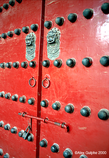 Photographie Couleur - Verticale - Portes laquées de rouge, décorées de clous et de deux <em>bi’an</em>