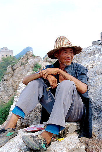 Photographie Couleur - Verticale - Vieil homme assis portant un chapeau de paille et une pipe à la main (II)