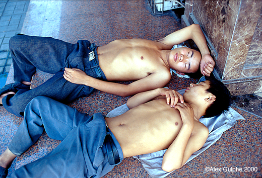 Photographie Couleur - Horizontale - Deux jeunes hommes endormis sur le trottoir à l’entrée d’un immeuble