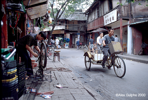 Photographie Couleur - Horizontale - Réparateur de cycles dans une rue du vieux Chengdu