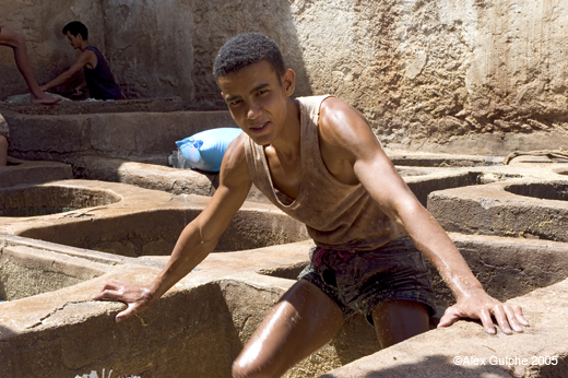 Photographie Couleur - Horizontale - Jeune ouvrier foulant des peaux dans un bain de rinçage
