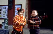 Photographie - Deux enfants riant à l’idée d’être pris en photo à l’entrée d’un jardin public