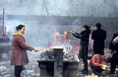Photographie - Femmes faisant offrande de bougies et de bâtons d’encens dans un temple bouddhiste