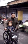 Photographie - Vieil homme promenant un jeune enfant sur son vélo
