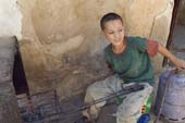 Photographie - Dinanderie, jeune ouvrier chargé du chauffage des pièces de métal
